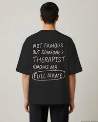 REVØRA Not Famous But Someone's Therapist Oversized T-Shirt – Oversized Shirt in Black, getragen, Rückenprint, KI-generierte Abbildung